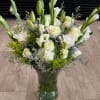 A mix of white roses, lilies, and greenery, arranged with accents of