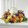 This urn arrangement has dark purple lisianthus, yellow daisies, yellow carnation, yellow