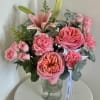 A lush garden-style arrangement featuring soft pink roses, spray roses, carnations and
