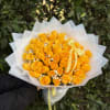 A beautifully gathered wrapped handheld bouquet of premium yellow roses, thoughtfully arranged