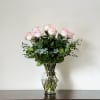 "A timeless arrangement of soft pink roses beautifully presented in a clear