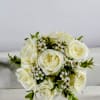 White spray roses and wax flowers mounted on a pearl bracelet. The