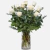 white roses in a vase with eucalyptus