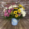 A cute periwinkle colored vase with white daisies.  And best of