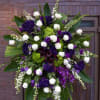 A beautiful mixture of purple and white flowers. The standing spray includes