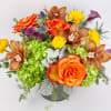 Colorful bouquet of roses, orchids, and yellow blooms in a vase
