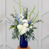White and blue floral arrangement in a cobalt vase