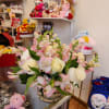Round arrangement of white roses and pink alstroemeria in a clear glass vase on a shop counter.