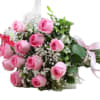 A cluster of medium-stem pink roses tied into a plush, hand-tied bouquet