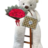Large teddy bear holding a bouquet of red roses and a box of Ferrero Rocher chocolates