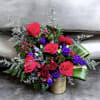 This arrangement has roses, lisianthus, alstroemeria, spray roses, aspidistra leaves, hypericum, limonium