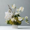 A modern, sculptural arrangement in soft ivory and fresh green tones, designed