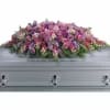 Soft shades of lavender, pink and purple mingle across a full casket