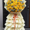 Bright yellow roses and oversized round yellow chrysanthemums take center stage in