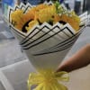 This wrap bouquet is made up of yellow roses and sunflowers wrapped