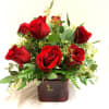 A compact cluster of rich red roses arranged low in a red