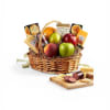 A low, oval wicker basket overflowing with fresh apples, bright citrus, makes