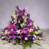 A lush, low triangular mound of roses, spray roses, asters, chrysanthemums and
