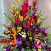 A tall, fan-shaped sympathy arrangement that reads like a celebration of a
