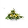 A low, elongated spray of yellow and white roses and lilies designed