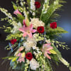 A thoughtful and memorie filled standing spray in shades of pinks, reds