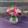 A delicate arrangement of flowers featuring Calla lilies and snapdragons .
