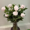 A classic arrangement of soft blush roses beautifully arranged in a clear