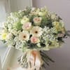 Soft blush roses and creamy gerbera daisies make an immediate, tender impression