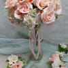 Soft peach roses gathered into a perfectly rounded, hand-tied bridal bouquet create