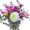 Features vibrant tulips, lilies, violets, carnations, chrysanthemum, and greenery .