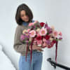 Woman holding a large pink and purple bouquet