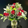 A dozen rich red roses mingle with delicate white filler blooms in