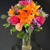 Vivid orange Asiatic lilies take center stage in this lively flower arrangement