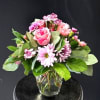 A bright, affectionate mix of pink roses, magenta-tipped carnations, and soft lavender-pink
