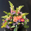 Peach roses clustered at the heart of this woven basket arrangement create