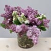 Lilac and white flowers arranged in a glass vase
