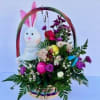 Upcycled Easter basket filled with hardy flowers and roses in seasonal colors