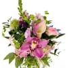 Mixed bouquet of pink orchids, calla lilies, roses, and hydrangea in a clear glass vase