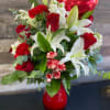 Bouquet of red roses, white lilies, and carnations in a red vase