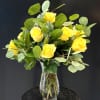 Sunlit yellow roses take center stage in this cheerful flower arrangement, a