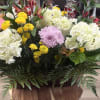 Mixed flower arrangement with white hydrangeas, yellow mums, and a lavender chrysanthemum