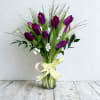 Elegant tulips gathered in a clear glass vase create a striking vertical