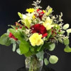 Bright red gerbera daisies and soft yellow carnations take center stage in