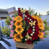 A bright cluster of sunflowers pairs with rich red and soft pink