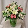 Pink roses and white lilies arranged in a clear glass vase