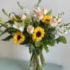 A beautiful arrangement of peach shimmer roses, sunflowers and stock! 