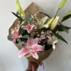 Mix color lilies arranged into a hand-tied bouquet with fillers and greens.