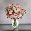 White roses with pink lilies in a clear vase 