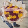 A dense, hand-held bouquet of red and bright yellow roses that reads