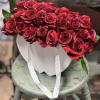 Bouquet of red roses in a white hatbox with white ribbon